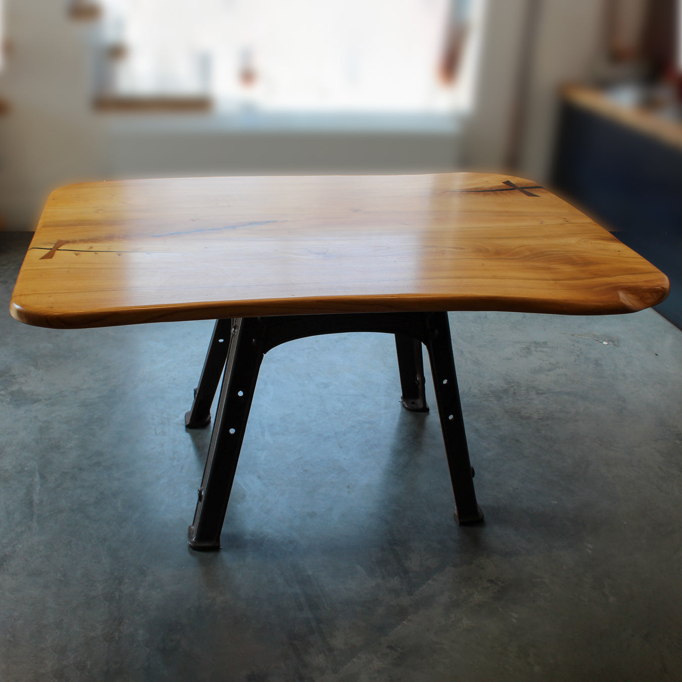 Full view of the Bamford Table showcasing live edge elm top and reclaimed cast iron base.
