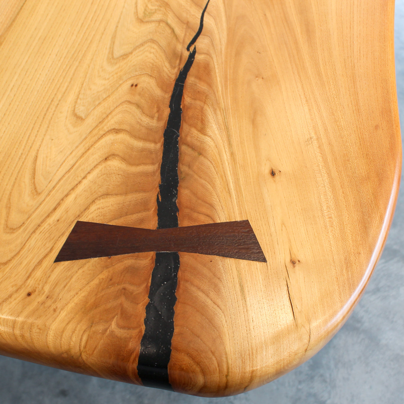 Close-up of wooden bowtie joints set into the live edge elm slab for structure and style.