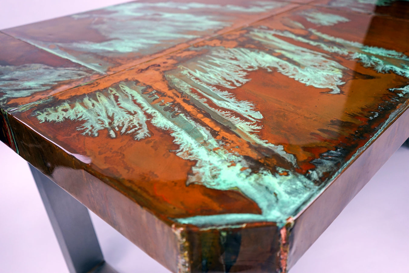 Table with a unique, bespoke multicolored patina copper surface design in a studio setting by The BOX Furniture