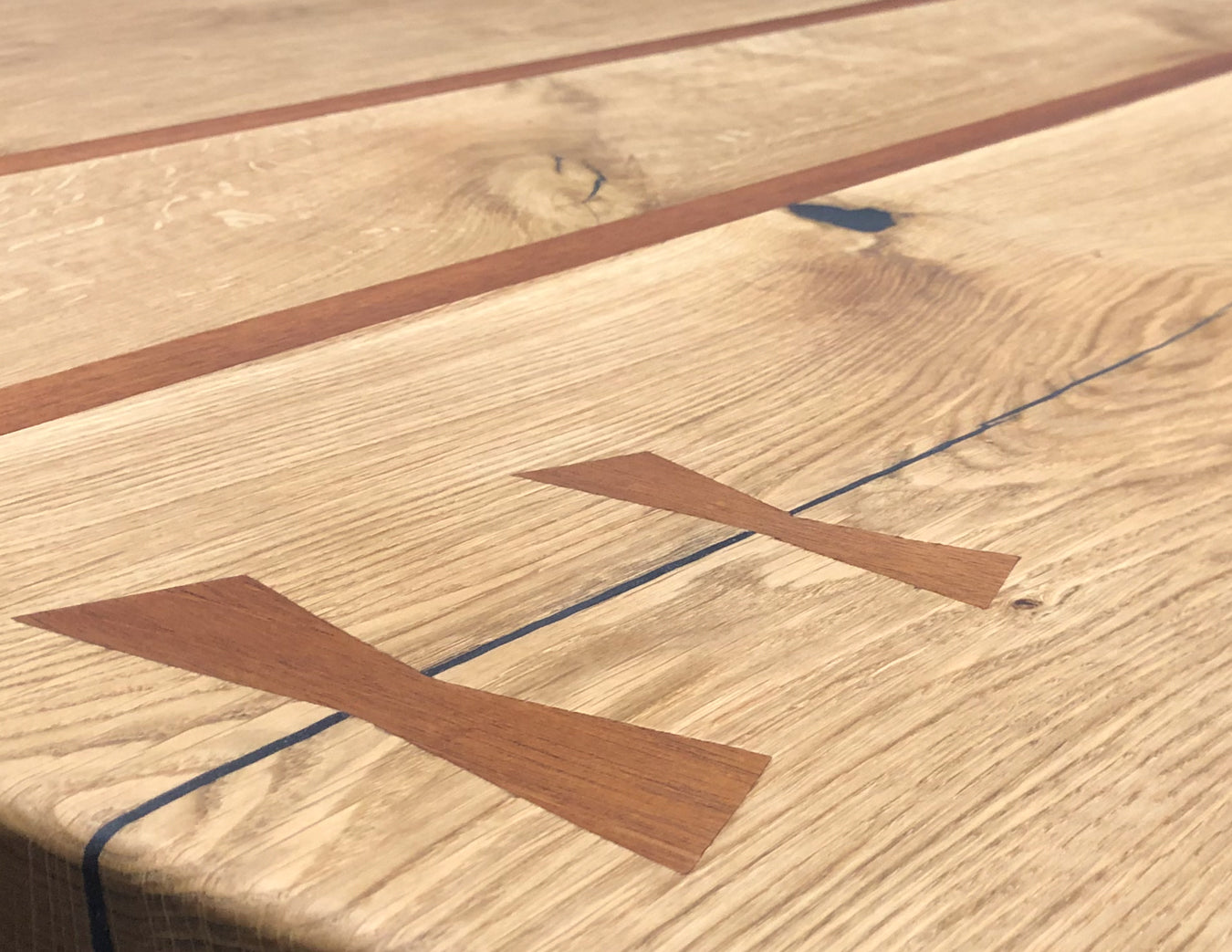 Close-up of a handmade elm dining table top surface with brown and black lines made by BOX Furniture