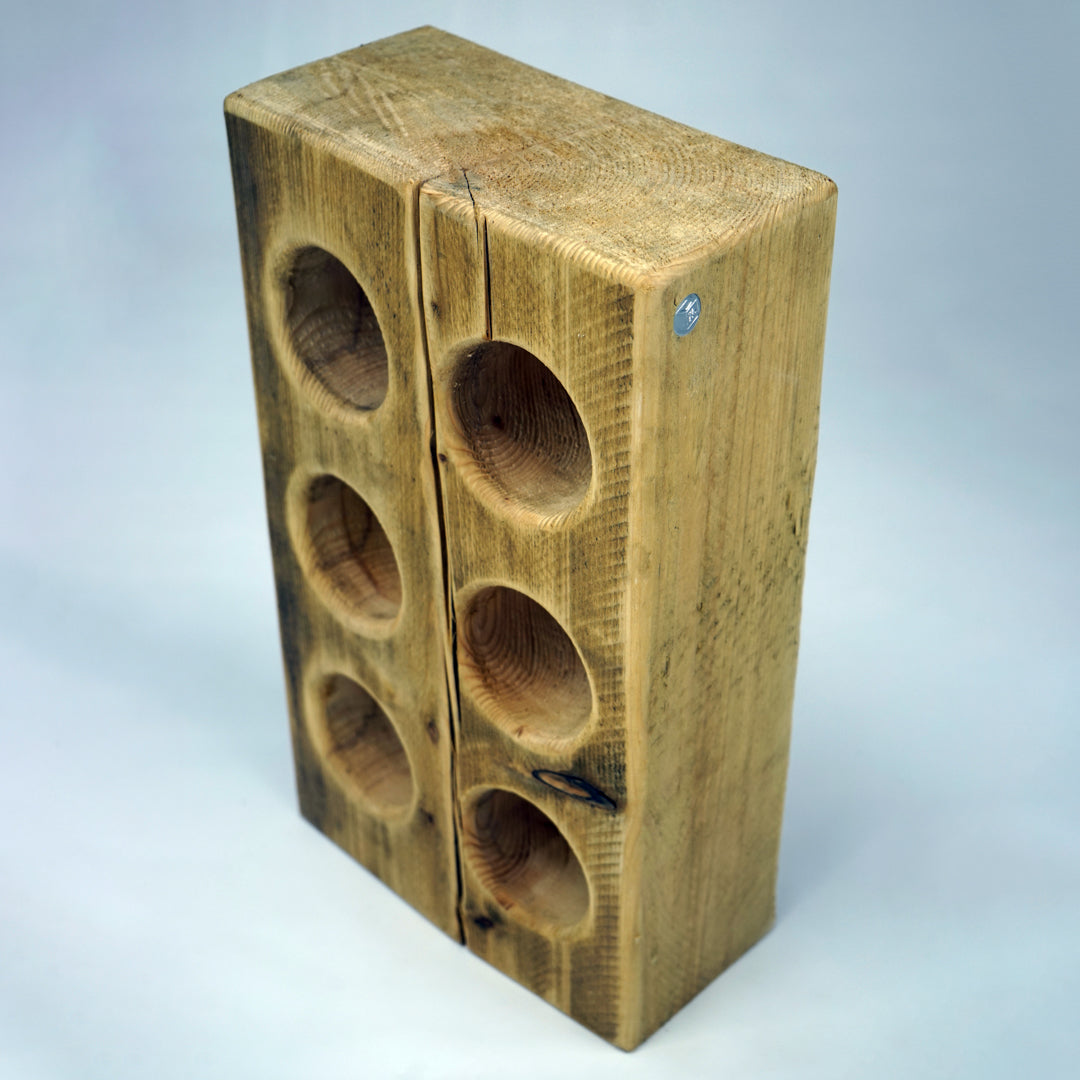 Studio-shot of a bespoke pine wine bottle cradle by The BOX Furniture.