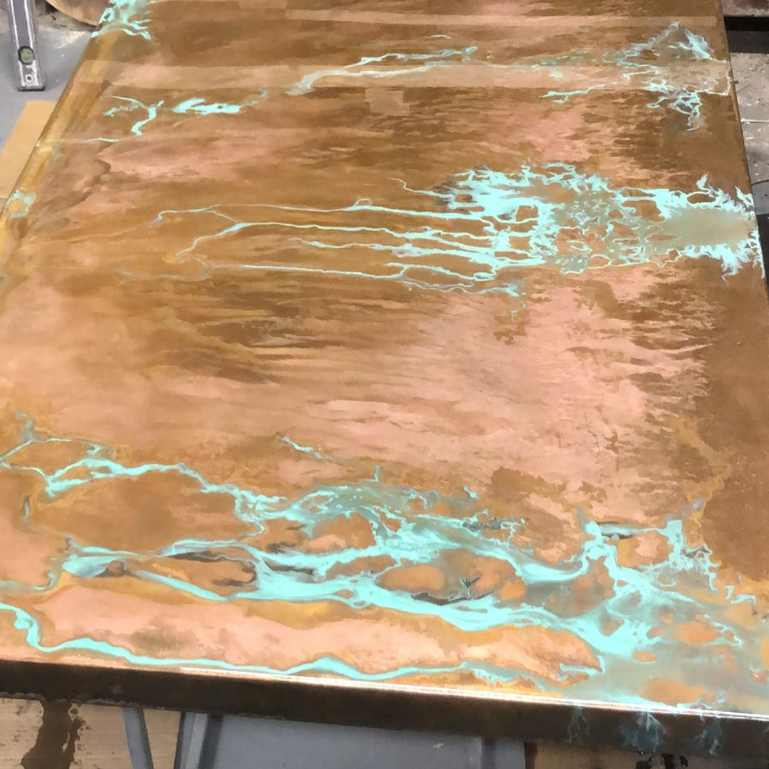Detailed view of green patina on copper, showing organic textures and colour variations.